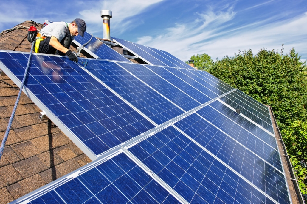 Handwerker befestigt Solaranlage auf einem Dach