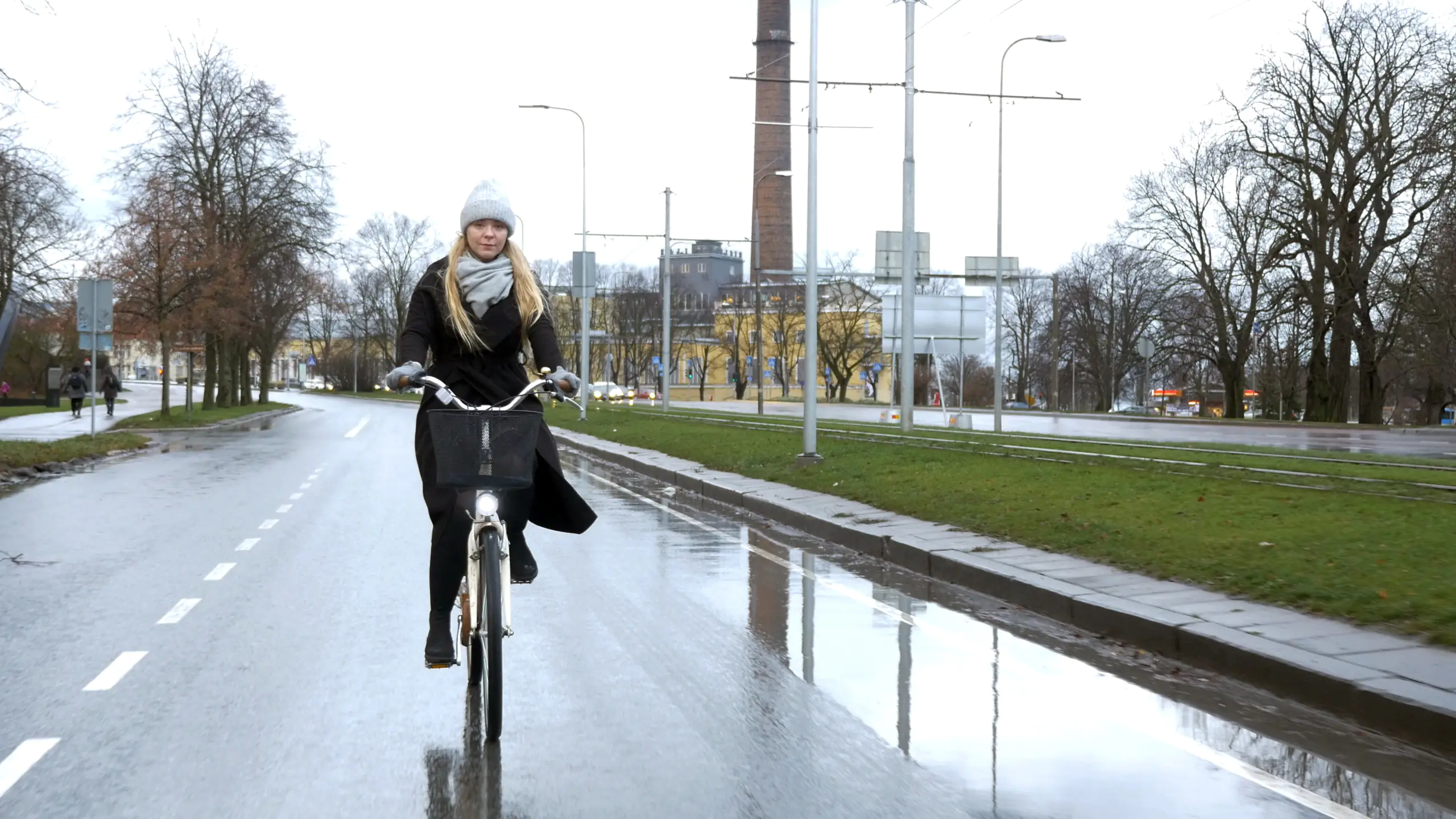 Frau auf Fahrrad auf nasser Straße